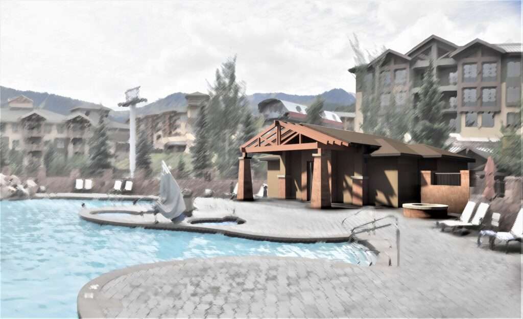 Outdoor pool area next to a rustic wooden cabin with mountains in the background.