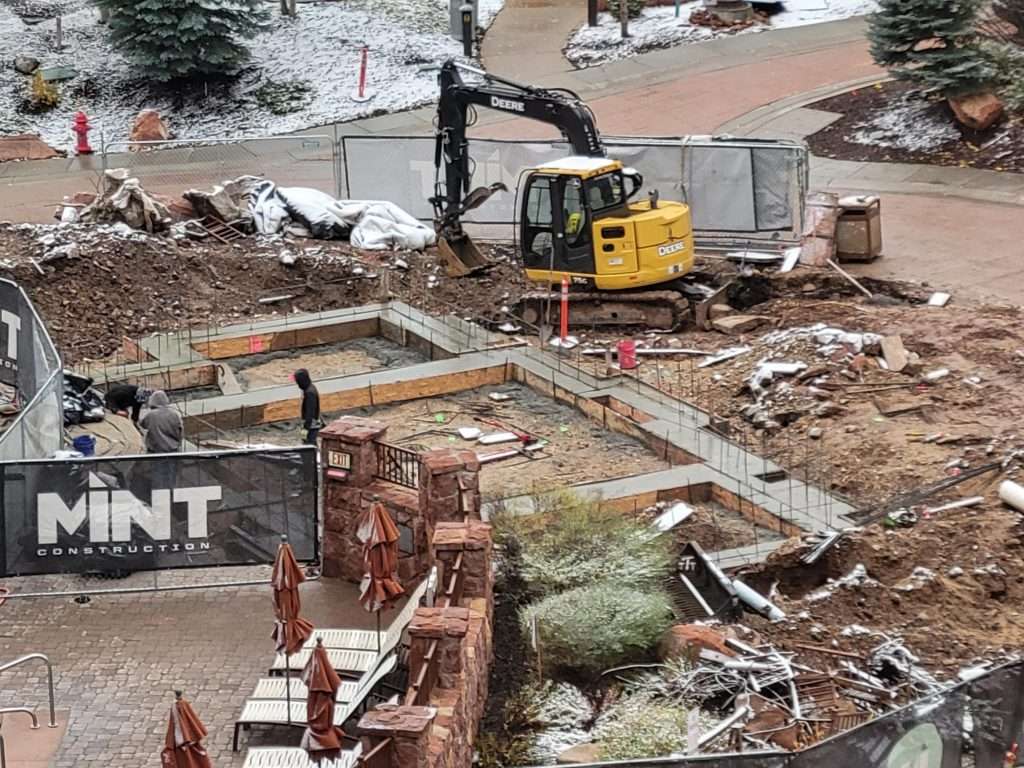 Construction site with excavator and building materials.