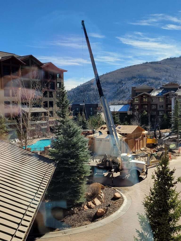 Crane lifting materials at a mountain resort construction site.