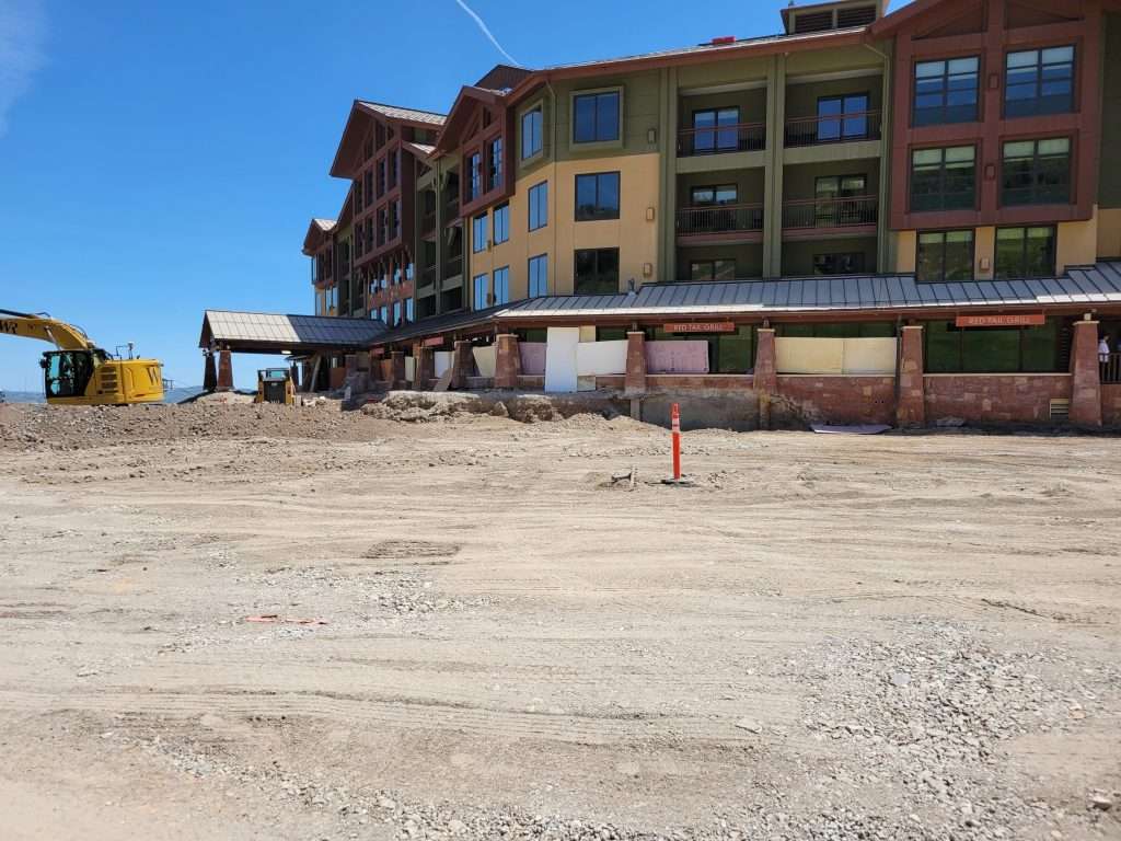 Construction site with a multi-story building under clear blue sky.