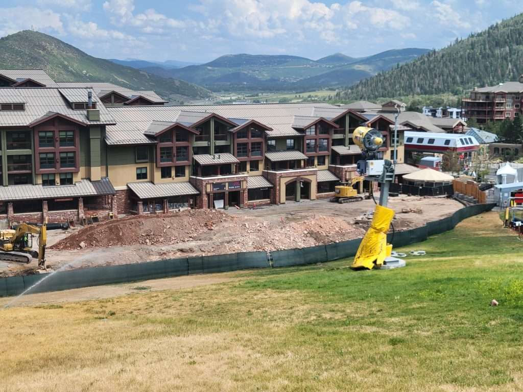 A large outdoor water park with slides and pools set against a mountainous backdrop.
