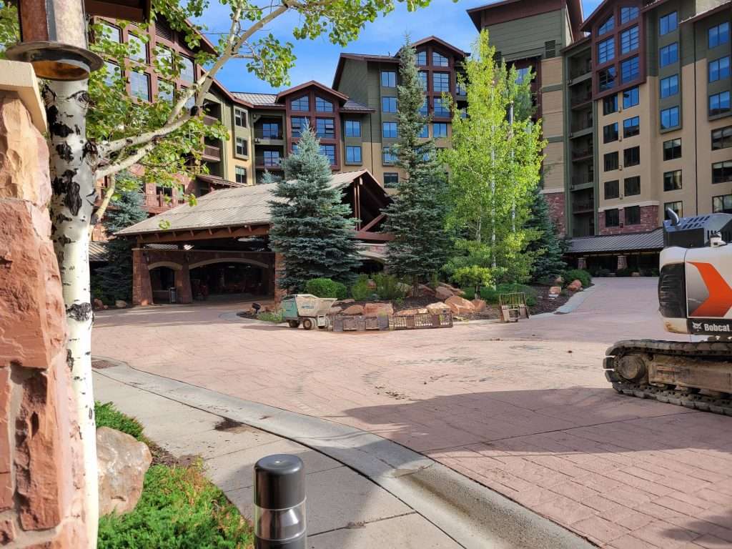 Scenic entrance of a rustic lodge with wooden beams and stone accents.