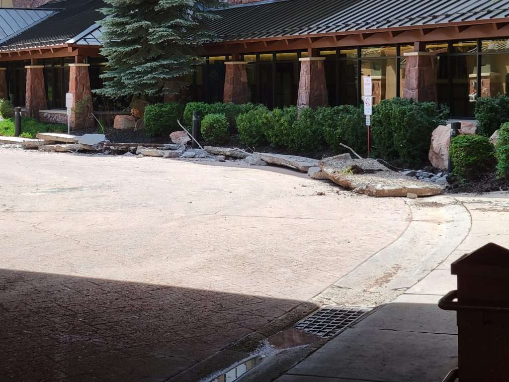 A serene Japanese garden with rocks and greenery beside a traditional building.
