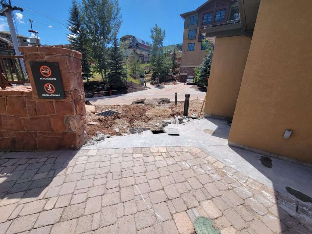 Driveway repair with removed damaged concrete and exposed soil.