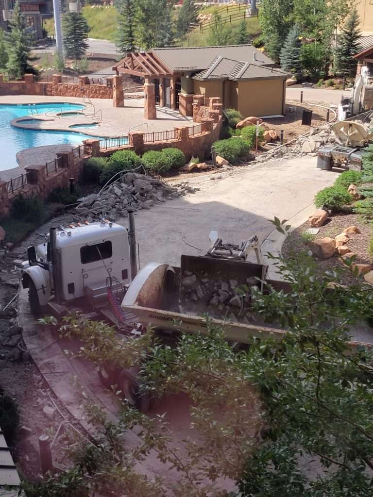 A miniature train crossing a small bridge in a garden setting.