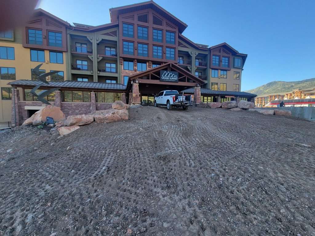 Entrance to a rustic lodge with stone and wood architecture under a clear blue sky.