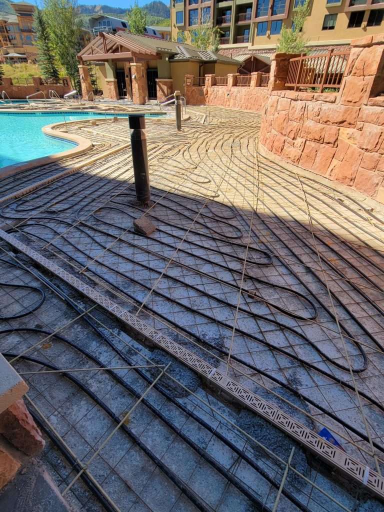 Intricate shadow patterns cast on a stone patio near a pool.