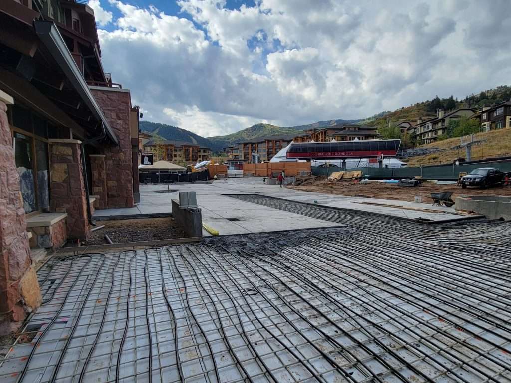Construction site with foundation and rebar under a cloudy sky.