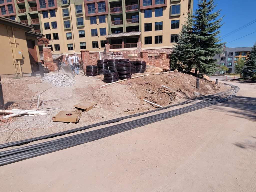 Construction site with building materials and a partially built road.