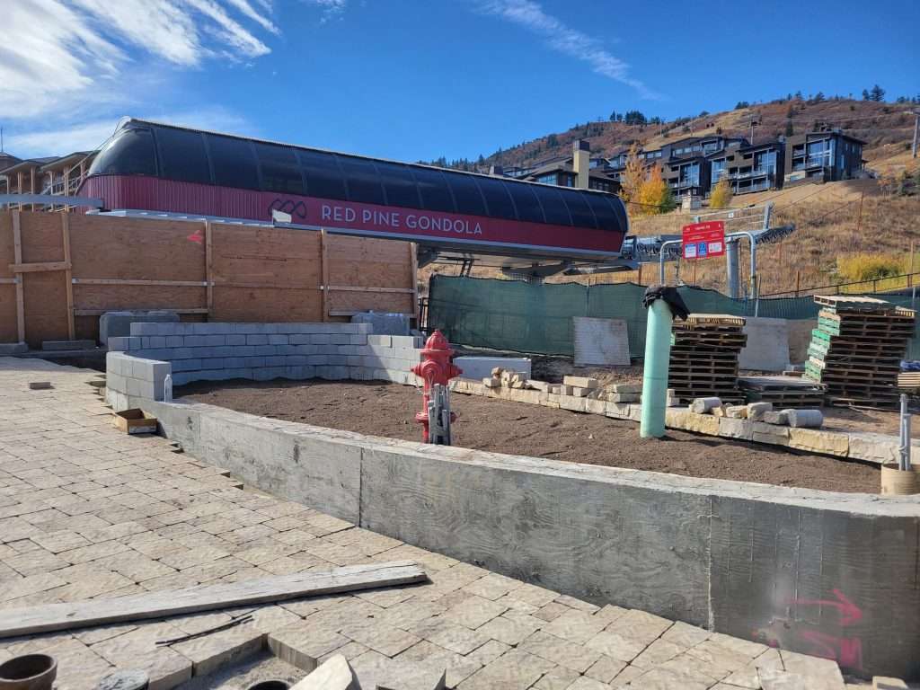 Construction site with workers and materials under a blue sky.