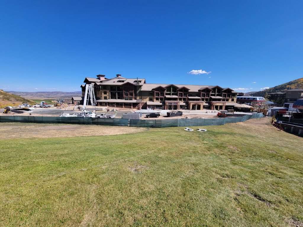 Large building by a green field under a clear blue sky.
