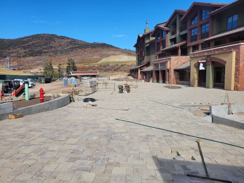 Construction site with brick pavement and a building under development.