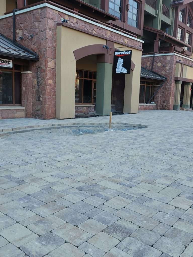Empty cobblestone street with brick buildings and a signpost.