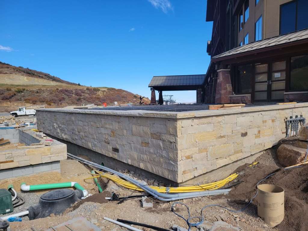 Construction site with a wooden foundation and clear sky.