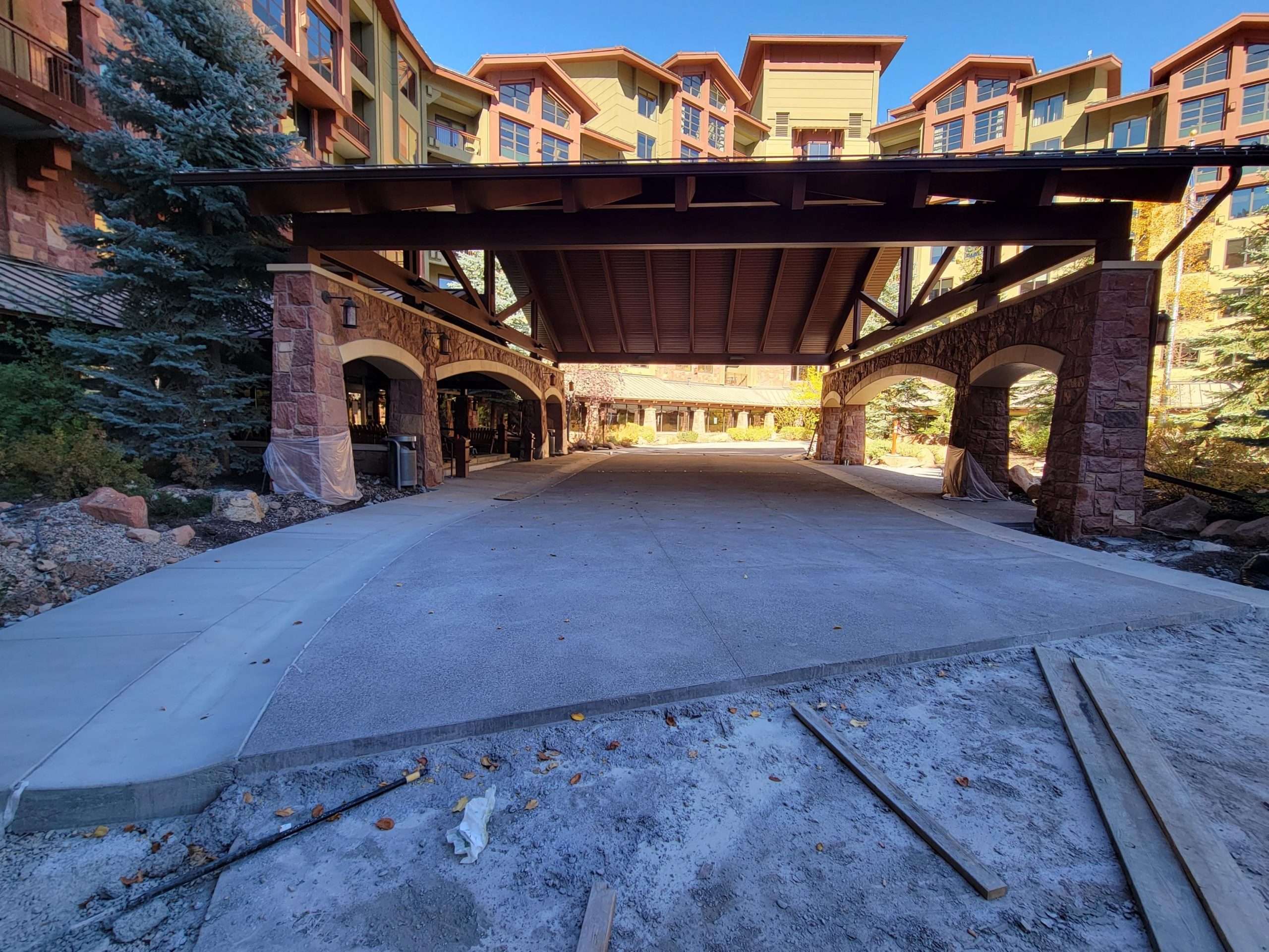 Covered outdoor parking area at a rustic residential complex.