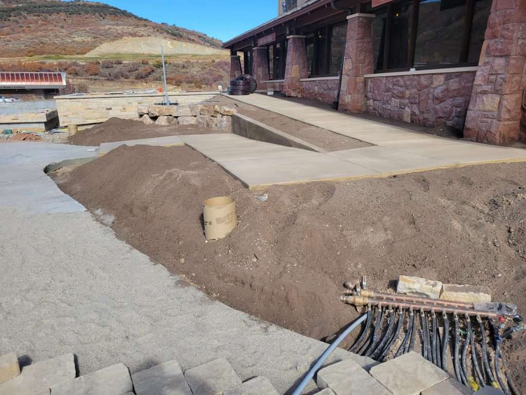 Archaeological excavation site with unearthed structures and tools.