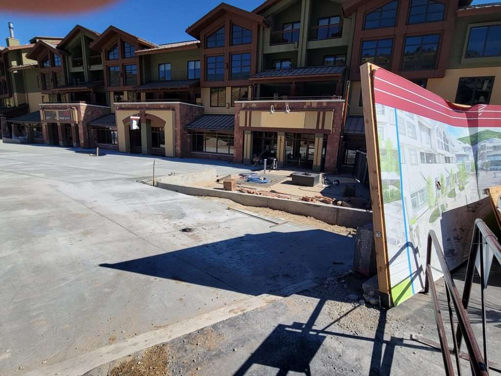 Construction site with a building and informational sign.