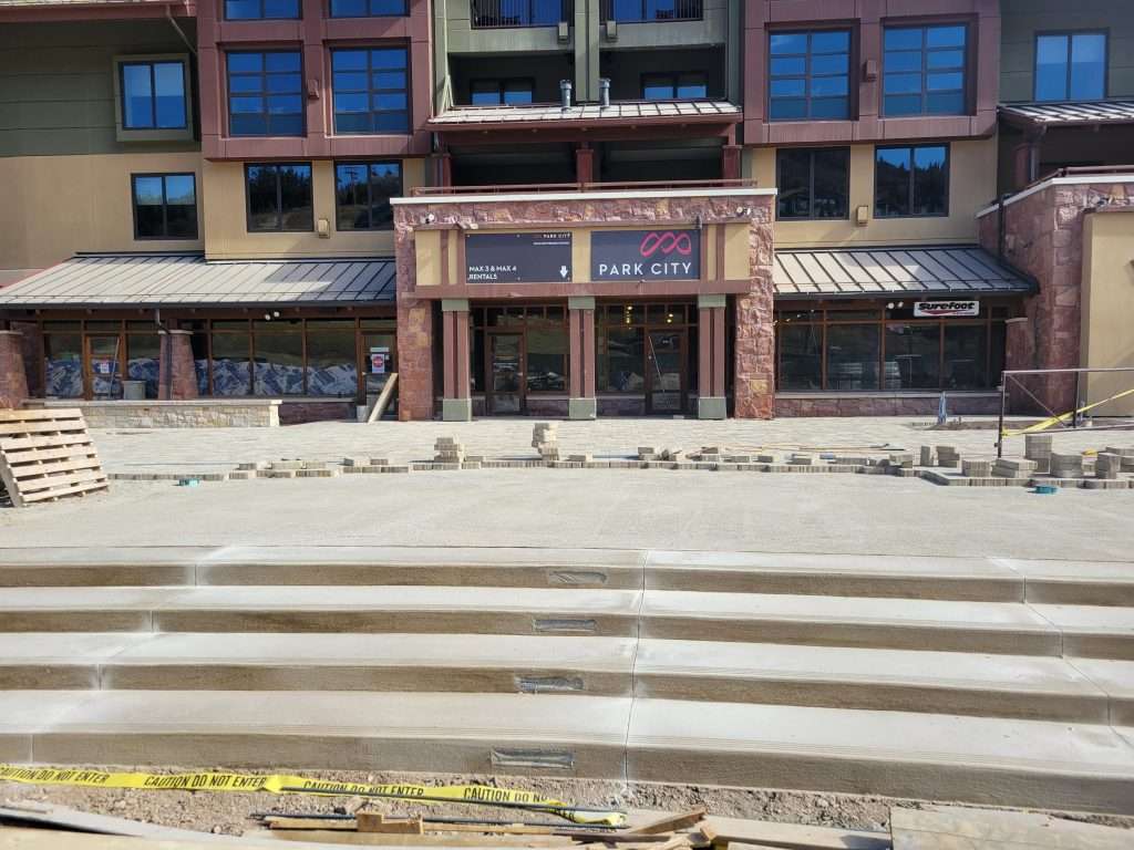 Wide stone steps leading to a building entrance with closed shops.