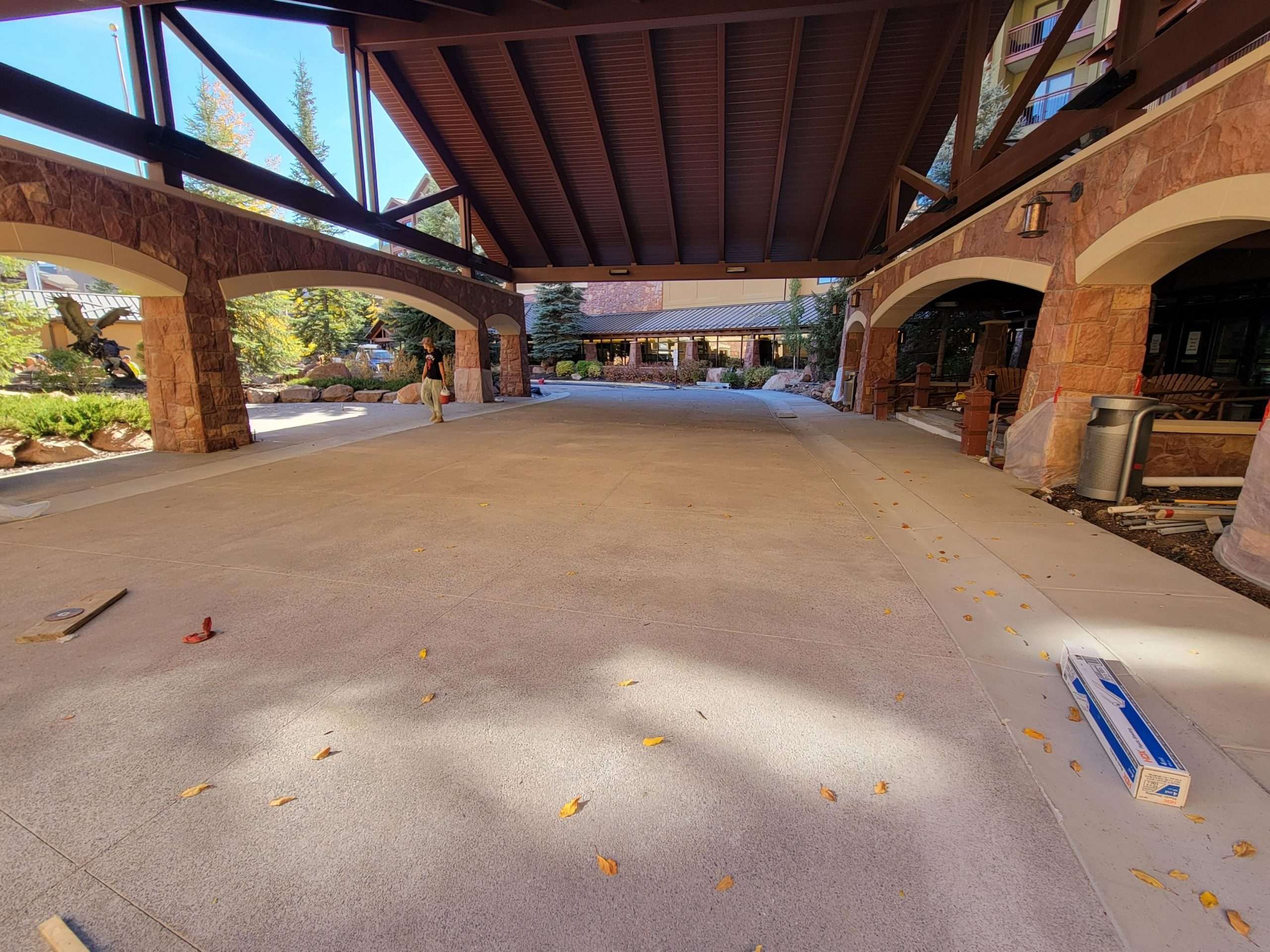 A spacious indoor garage with a car and brick walls.