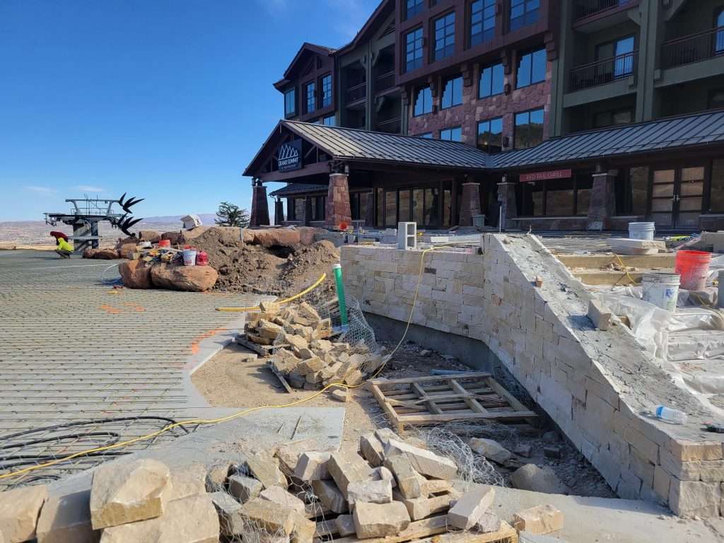Stone stairs and wooden deck leading to a building under clear blue sky.
