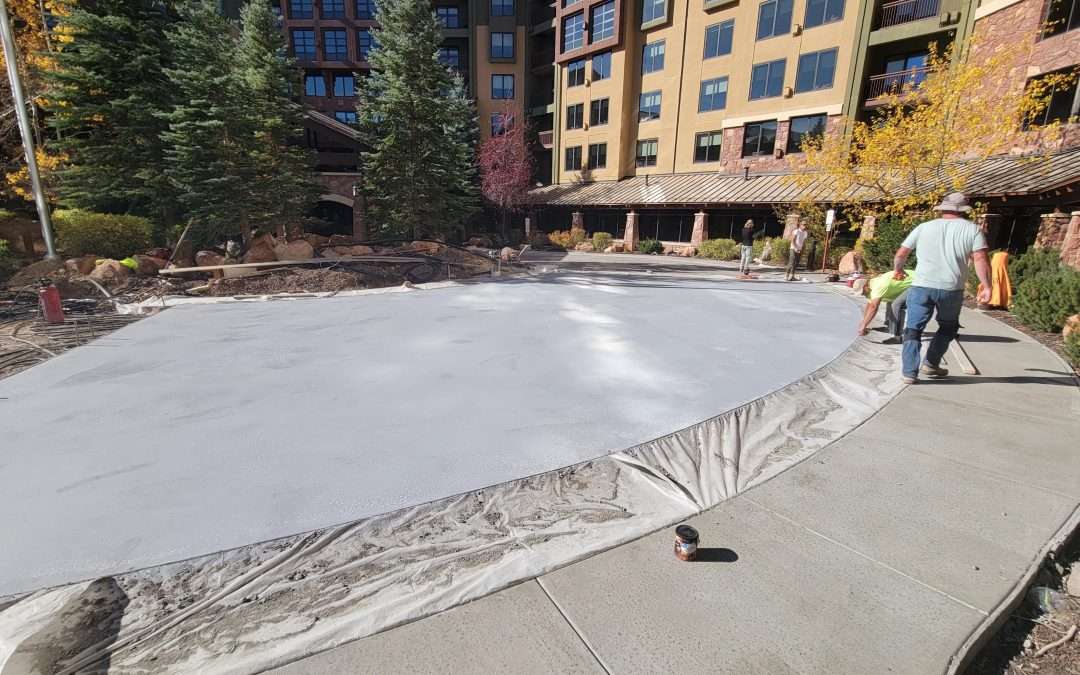 Frozen ice rink outside a lodge in a snowy mountain area.