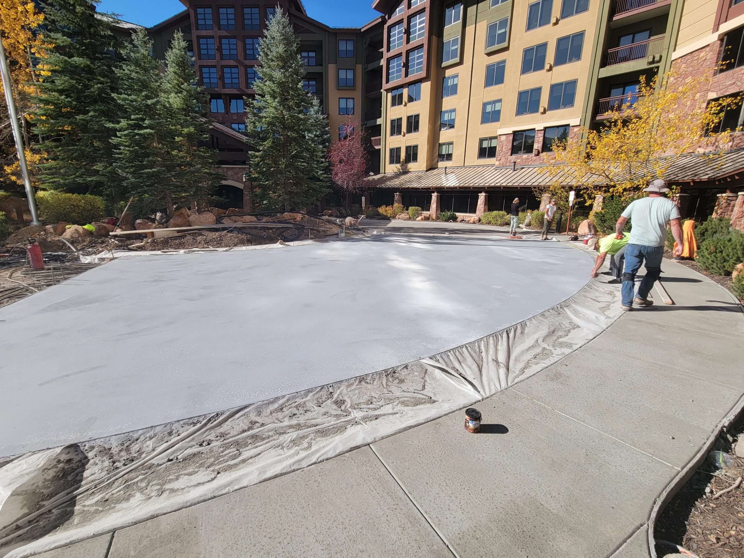 Frozen ice rink outside a lodge in a snowy mountain area.