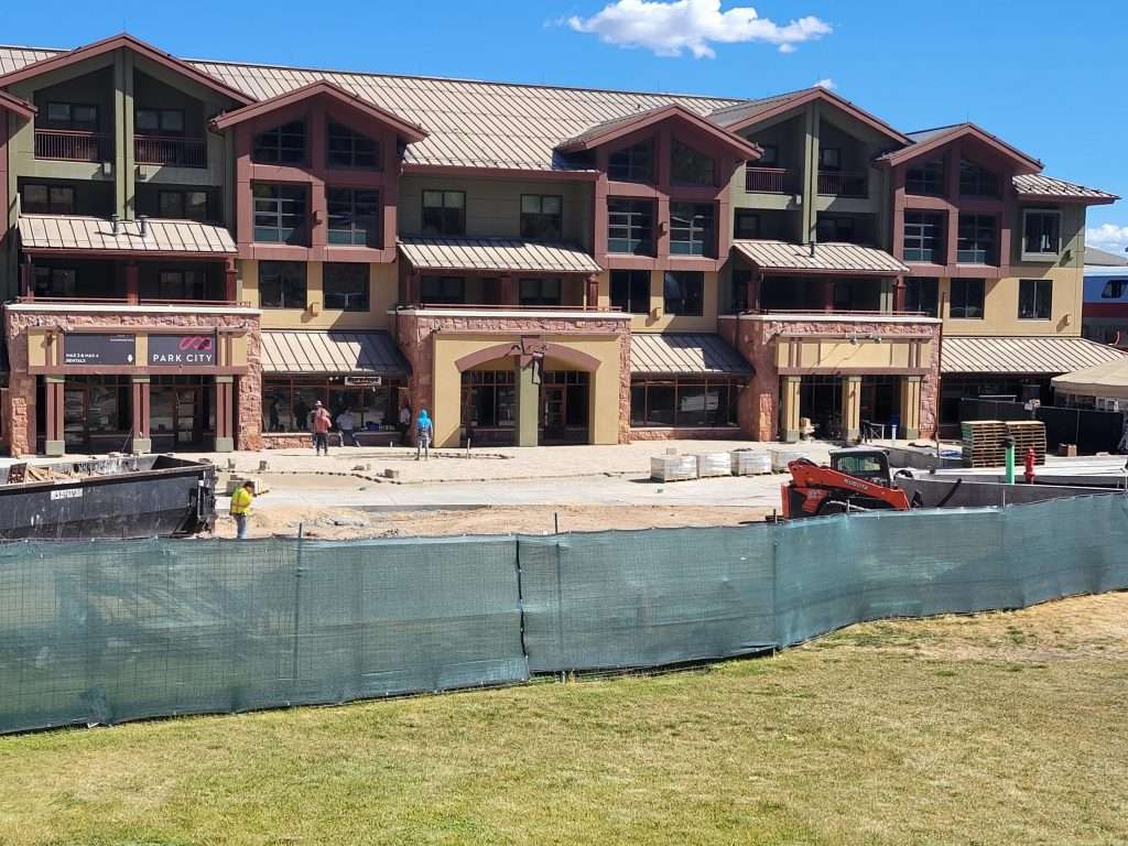 A large building under construction with scaffolding and fencing around it.