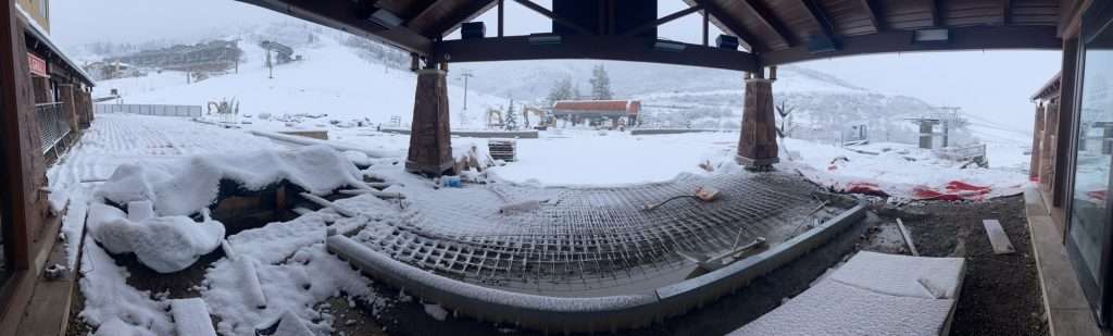 Snow-covered hammock under a shelter with a snowy landscape beyond.