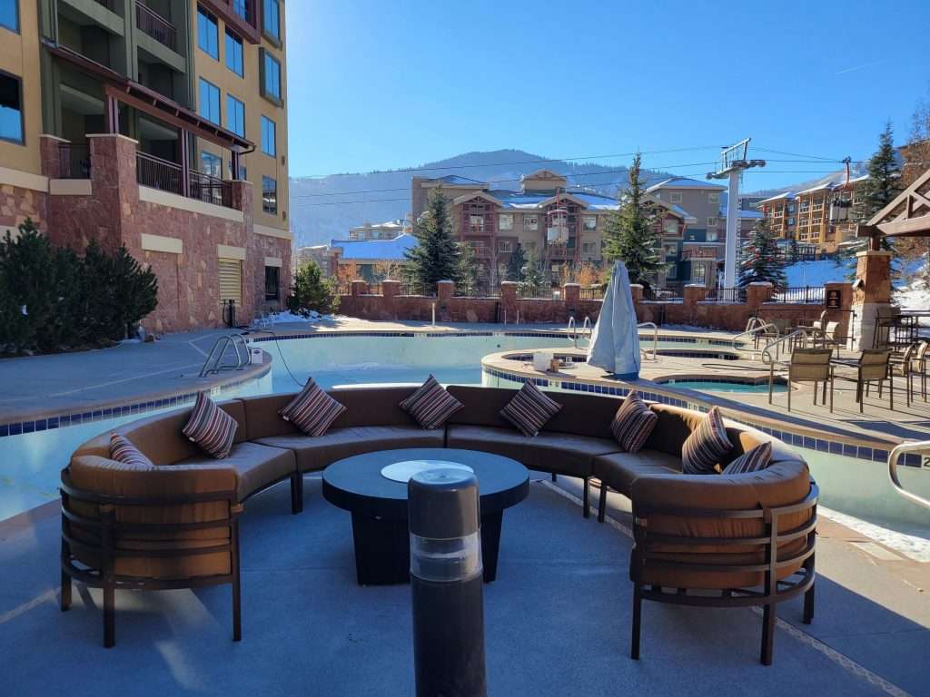 Modern outdoor seating area with curved sofas and a central firepit.