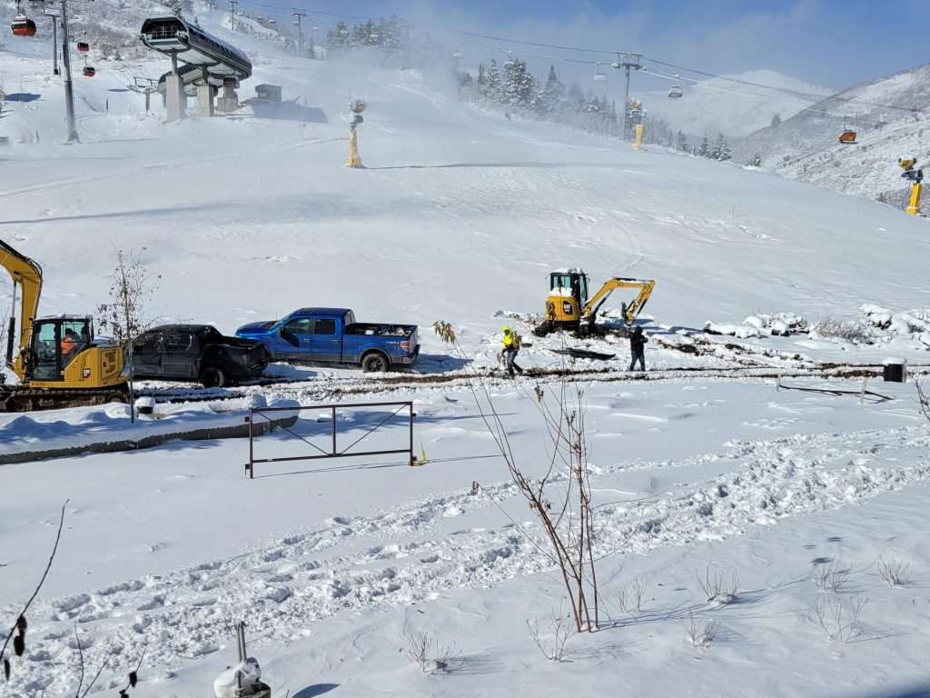 Snow-covered ski resort with ski lift and snowy mountains.