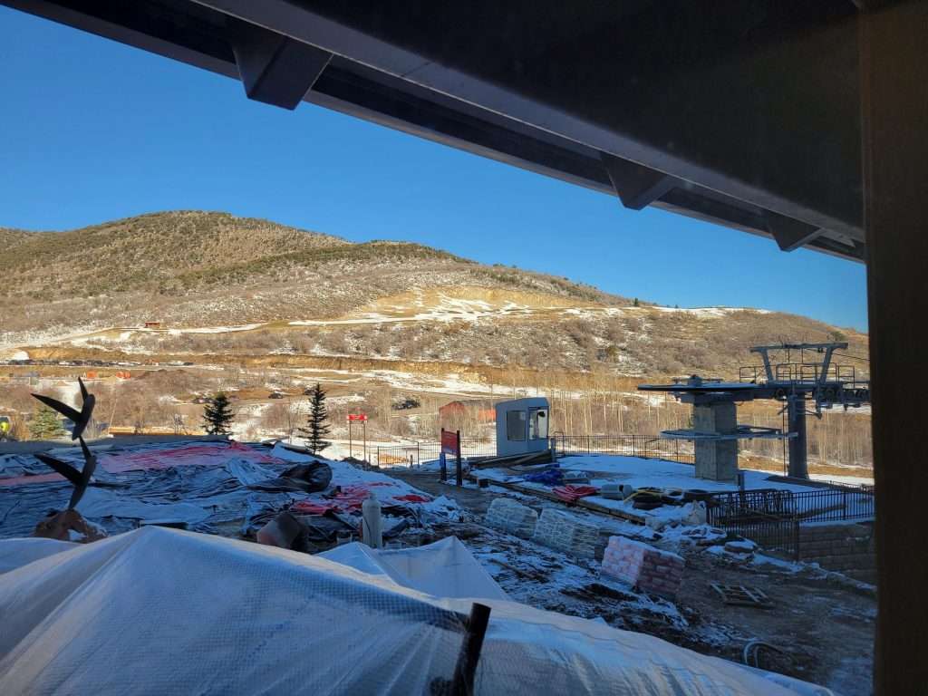 View of a snowy mountain landscape from a covered terrace or balcony.