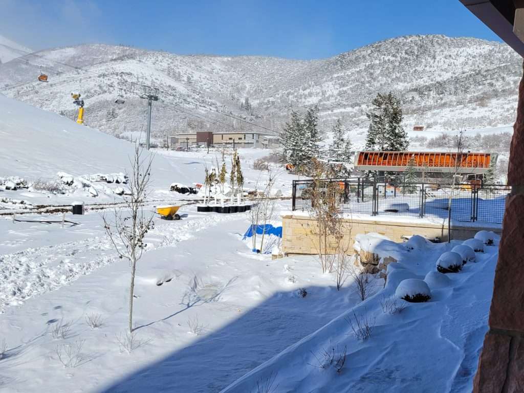 Snow-covered mountain village with clear blue sky and scattered buildings.