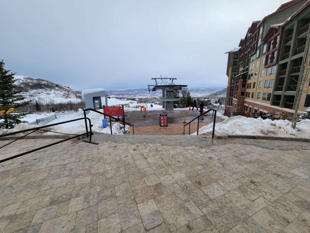 Snowy mountain ski resort with a chairlift and buildings.