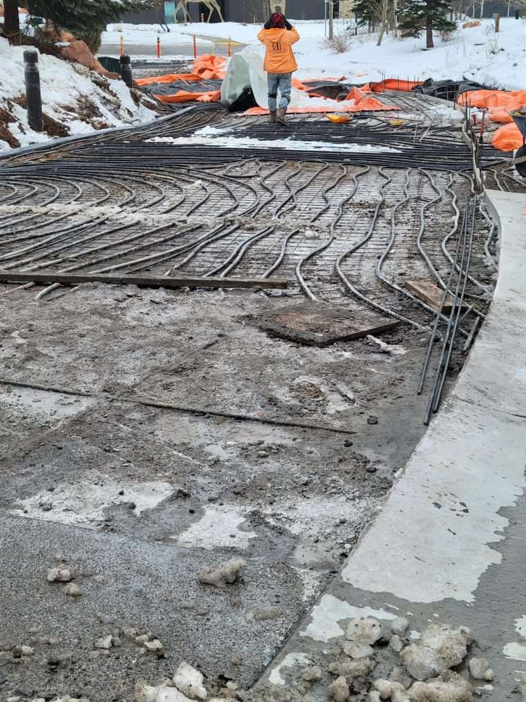 Workers smoothing wet concrete on a construction site.