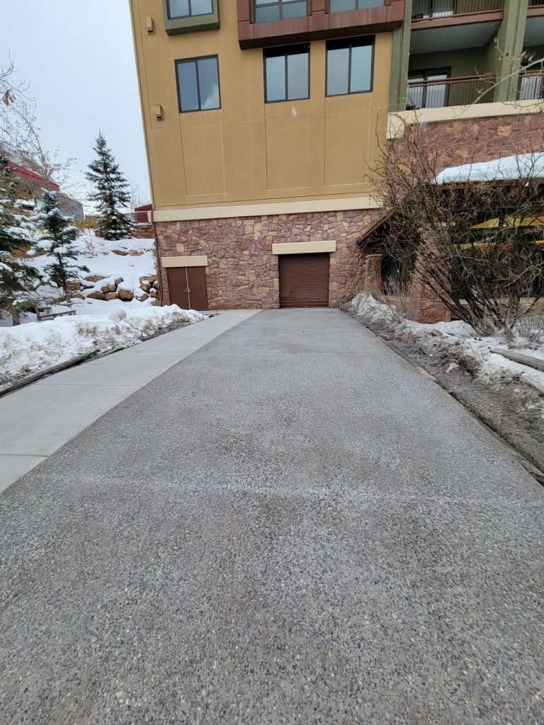 Snow-covered driveway leading to a closed garage door.