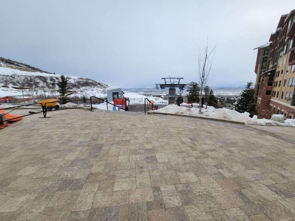 Snowy mountain resort with ski lift and playground area.