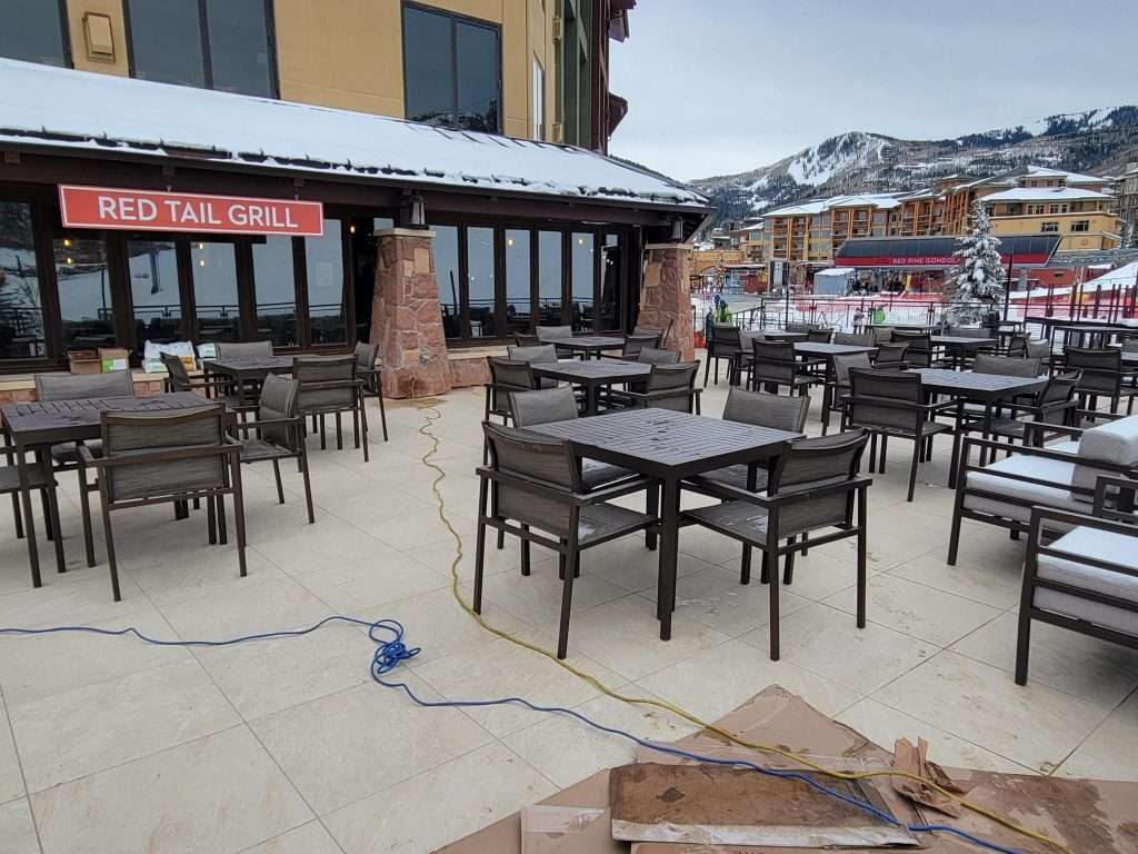 Outdoor seating area with tables and chairs on a patio.